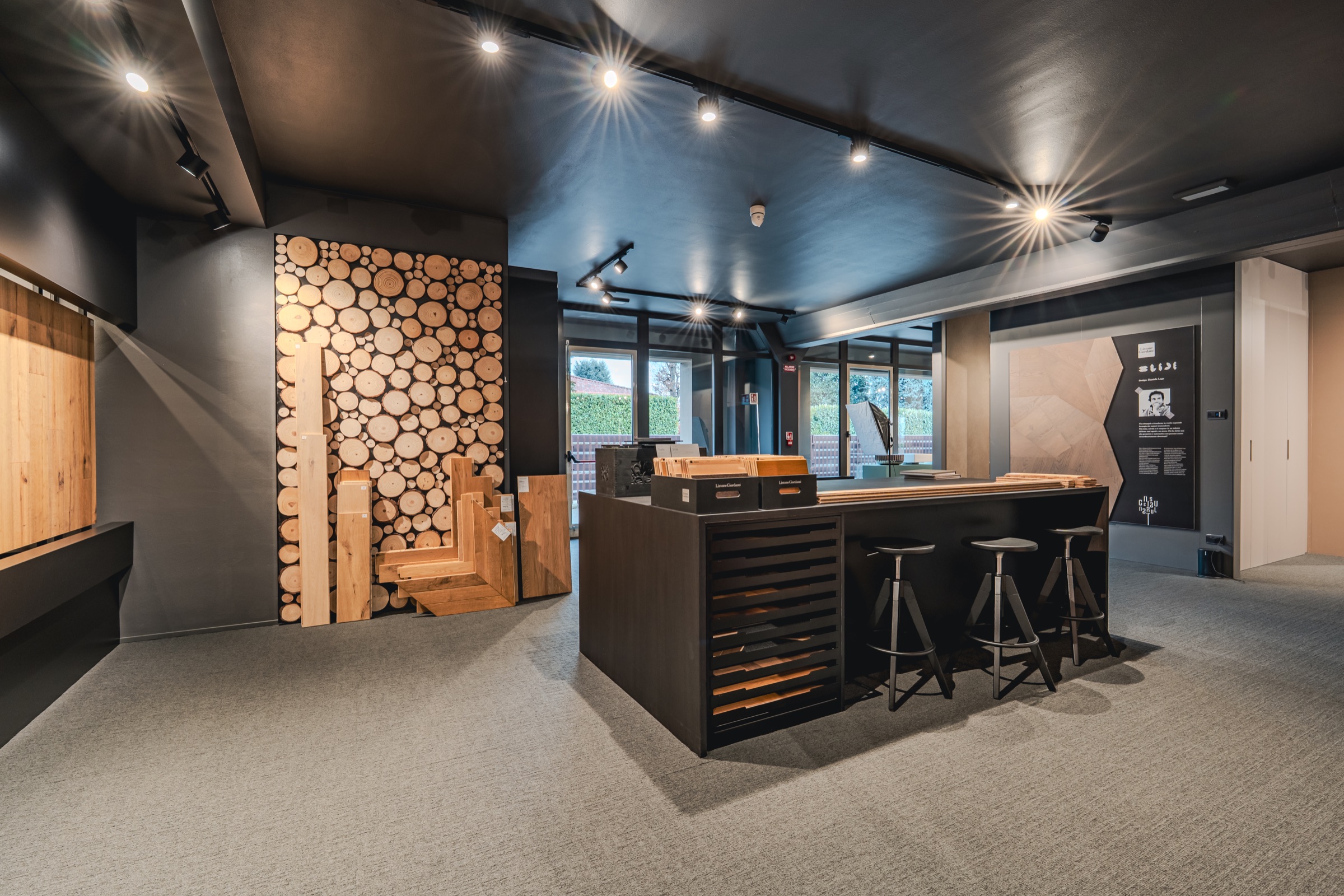 Area bar nello showroom con tronchi decorativi e sgabelli